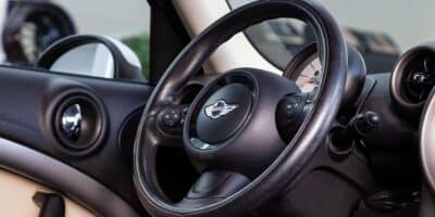 Interior shot of a Mini Cooper Countryman focused on the steering wheel and driver door panel.