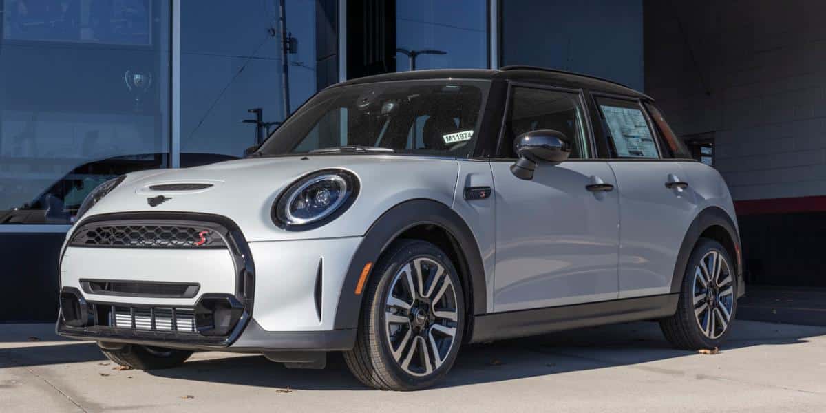 A silver 2022 Mini Cooper Hardtop 4-door parked outside the dealership showroom windows.