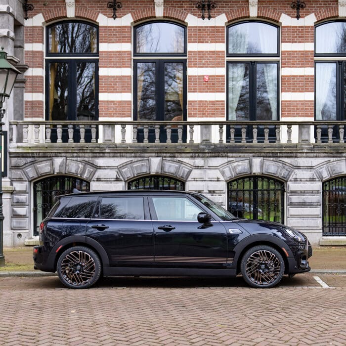 Side profile image of a navy 2024 mini cooper clubman.