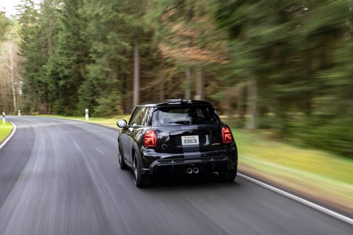 The rear-view John Cooper Works Mini driving down a highway.