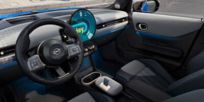 A sleek and modern interior view of the 2025 MINI Cooper, featuring a rounded digital display and premium controls, showcasing potential for customization with Mini Cooper parts.