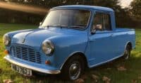 Classic Mini Cooper Truck in Blue parked on grass