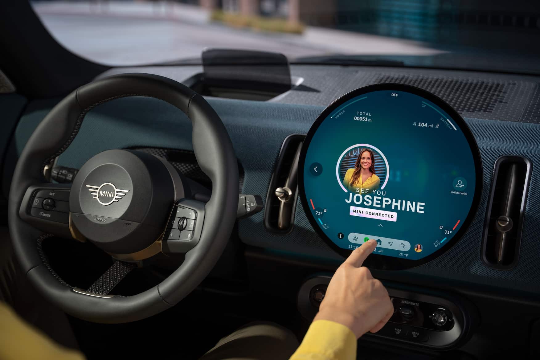 A close-up of the Mini Cooper’s digital dashboard and steering wheel, showcasing advanced safety features. The Mini Cooper crash rating highlights its modern safety technology.