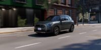 MINI Cooper SE electric hatchback driving on city street showcasing its distinctive styling and compact design