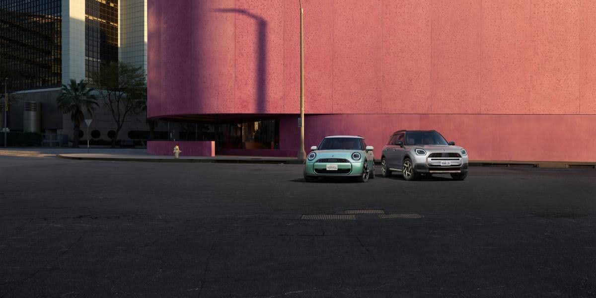 2023 Mini Cooper parked beside Mini Cooper 2022 in city street setting, showing design differences between both model years.