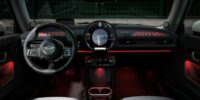 Interior of a Mini Cooper dashboard with illuminated controls and navigation screen, representing steps to replace car battery and maintain vehicle care.