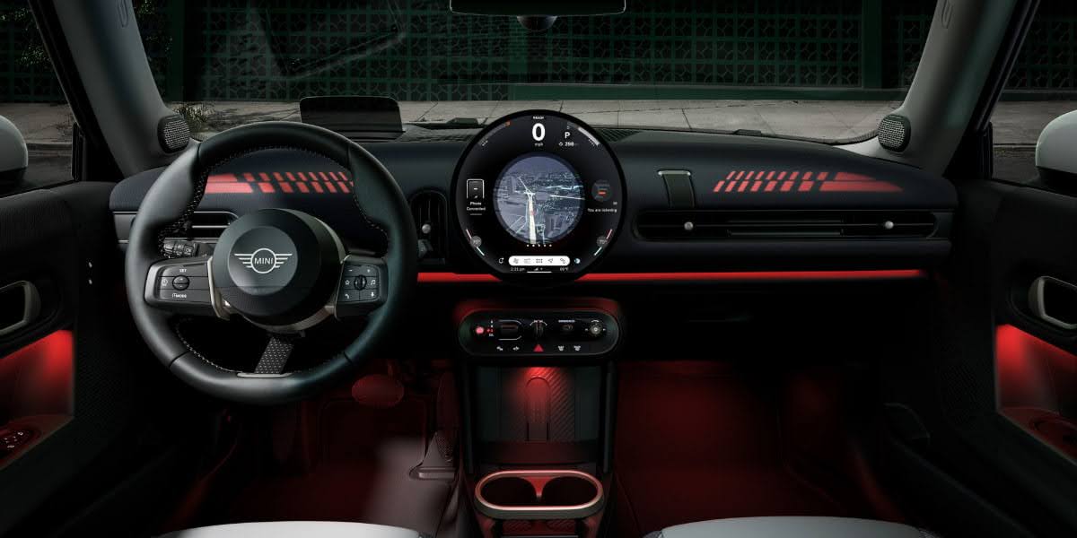 Interior of a Mini Cooper dashboard with illuminated controls and navigation screen, representing steps to replace car battery and maintain vehicle care.