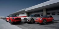 Three Mini Cooper trims—Classic, Favoured, and John Cooper Works—parked side by side, highlighting design and styling differences in 2025 models.