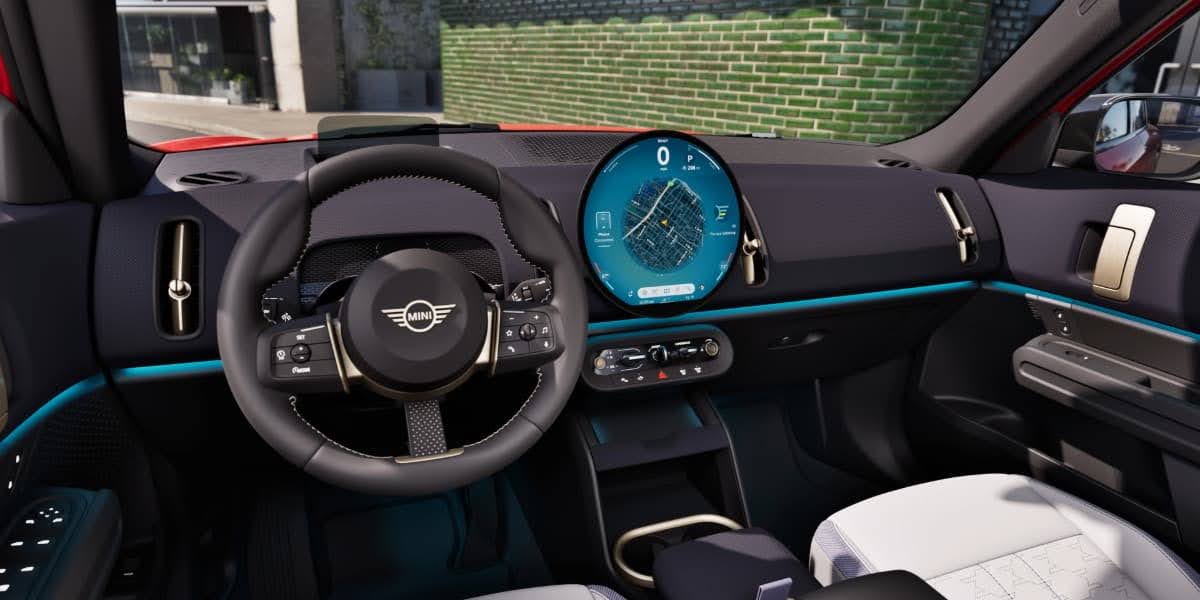 Interior dashboard view with circular OLED display and steering wheel showing Mini Connected infotainment system in a 2026 MINI vehicle